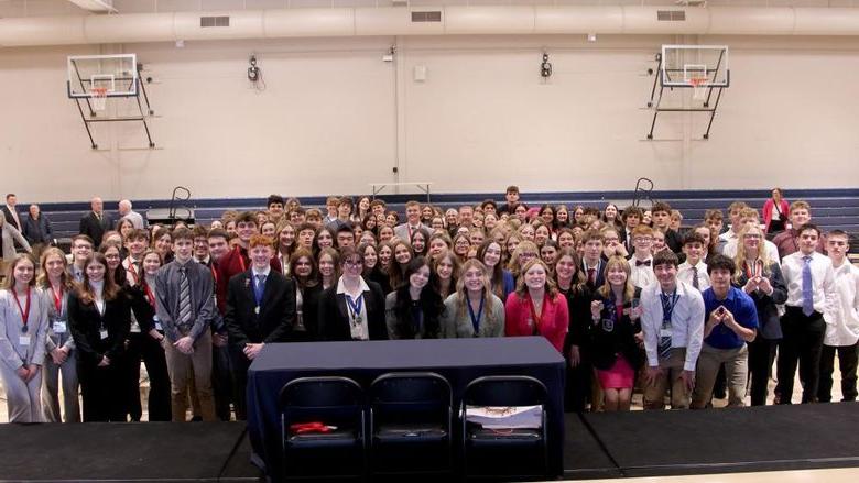 All students who participated in the 2024 Pennsylvania DECA District 1 conference gather for a group photo on the gym floor at the PAW Center, on the campus of Penn State DuBois.